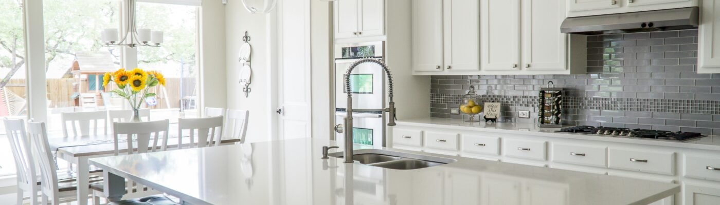 Spacious modern kitchen with white cabinets and island in natural light.