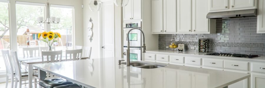 Spacious modern kitchen with white cabinets and island in natural light.