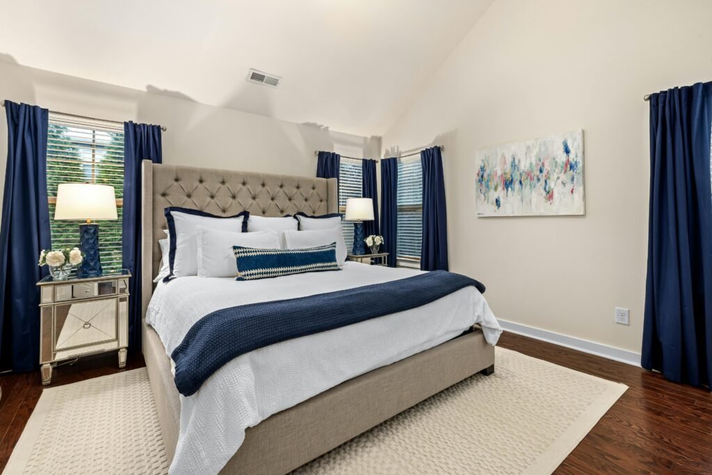 A stylish bedroom interior with a modern touch, featuring blue accents and a cozy bed setup.