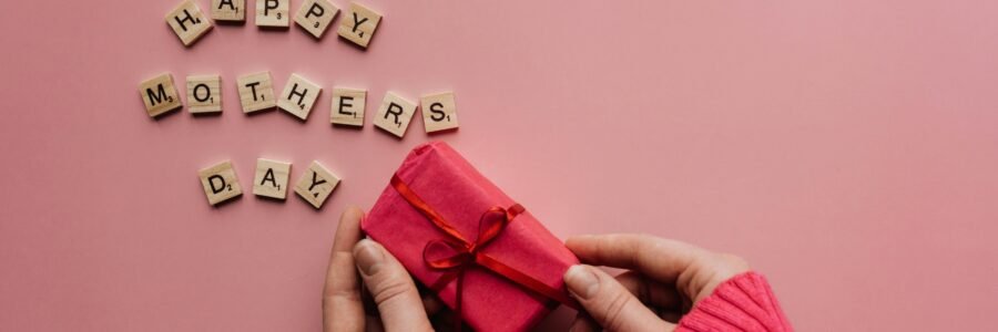 A heartfelt Mother's Day greeting with a gift on a pink background.